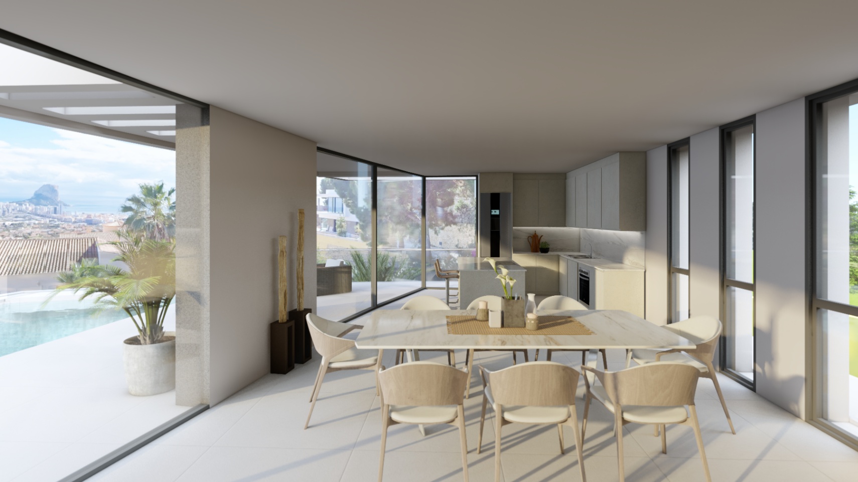 Comedor de concepto abierto con mesa de mármol y cocina integrada, conectado a la terraza con piscina y vistas panorámicas al Peñón de Ifach.