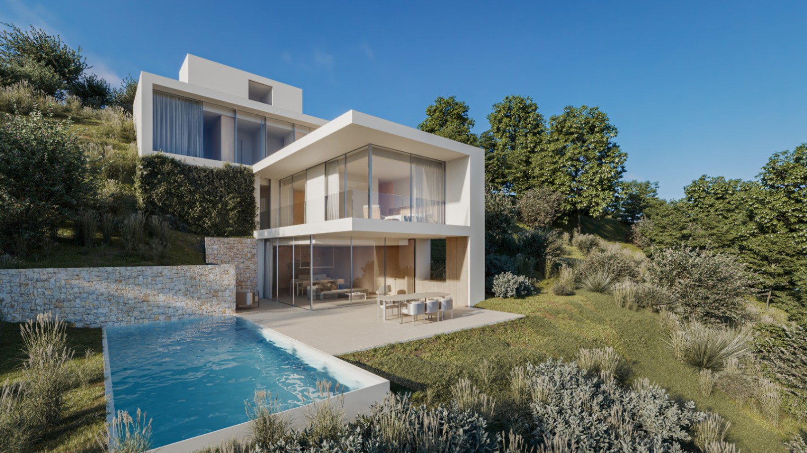 Vista exterior de la villa moderna con arquitectura de cubos blancos, piscina desbordante y muros de piedra natural integrados en la ladera ajardinada.