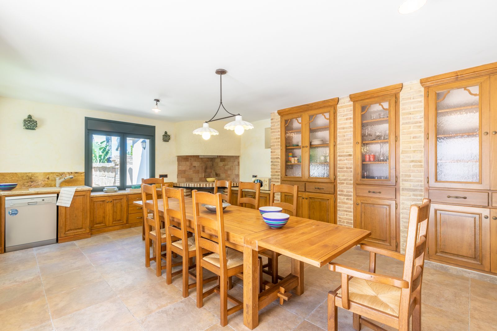 Comedor con mesa de madera maciza y alacena empotrada de ladrillo visto.