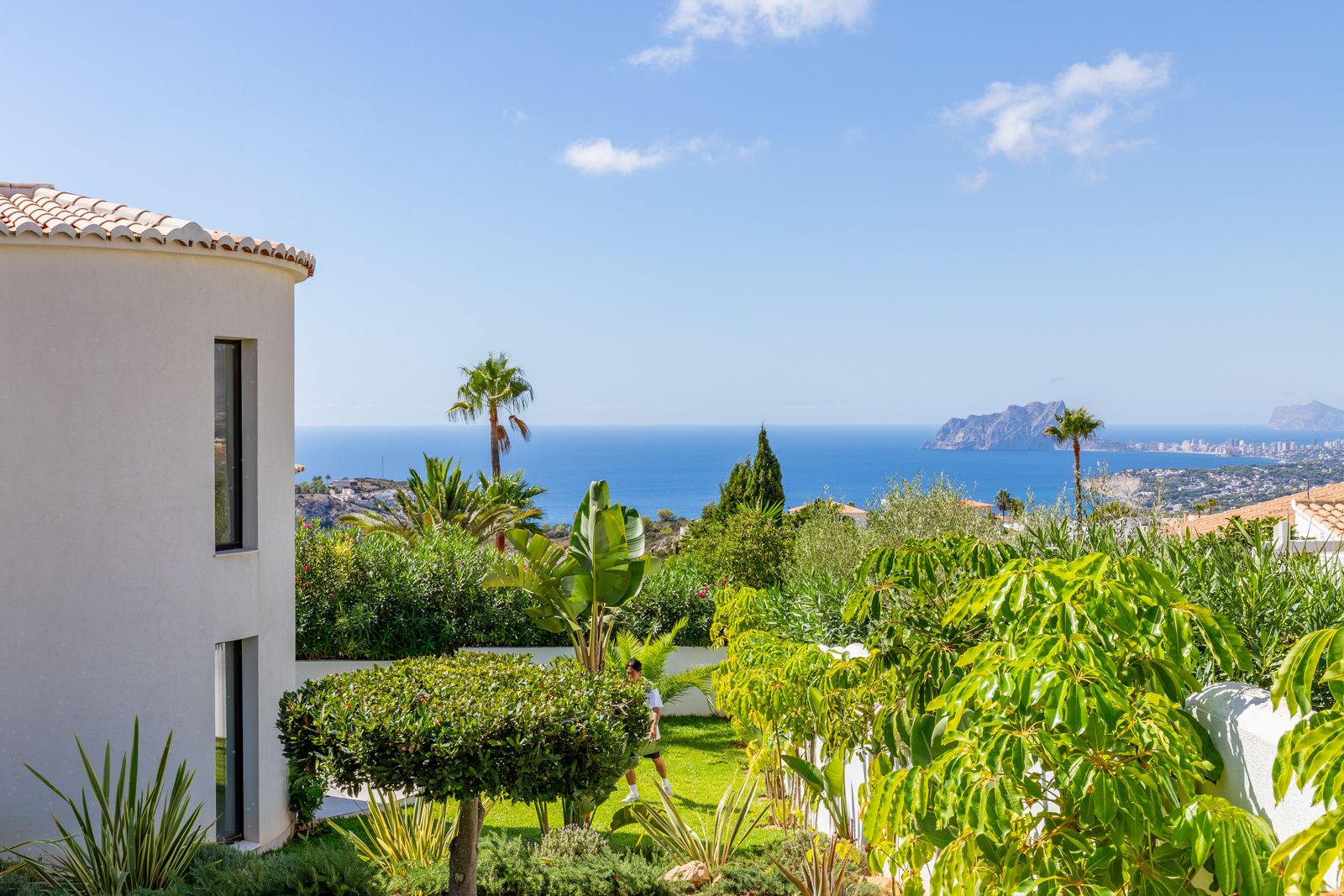 Vistas panorámicas al mar Mediterráneo y al Peñón de Ifach desde el jardín mediterráneo de diseño que rodea la fachada curva de la villa.