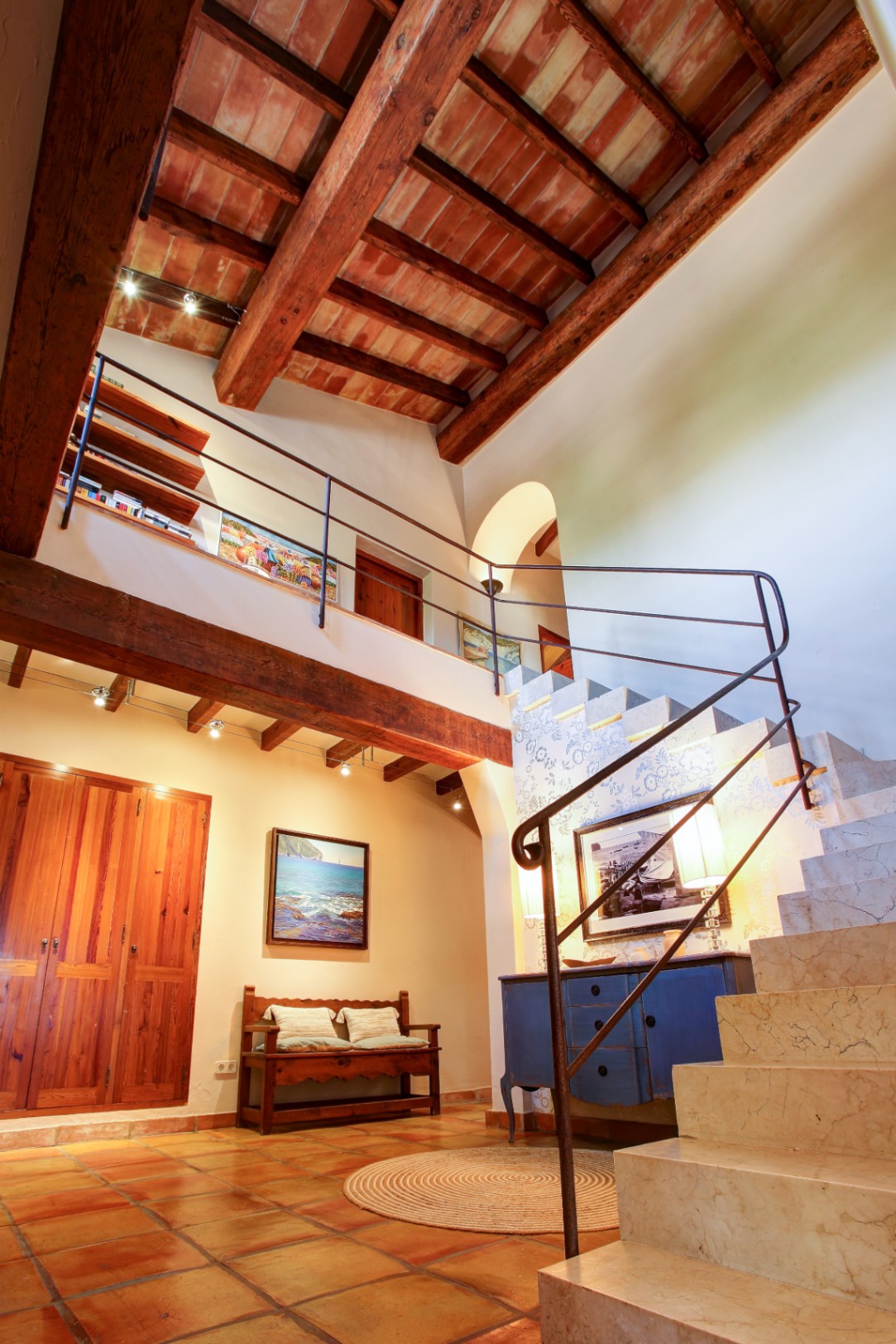 Hall de entrada con techos de doble altura, vigas de madera de mobila y bovedillas. Destaca la escalera de mármol macizo con barandilla de forja y suelos de barro cocido.