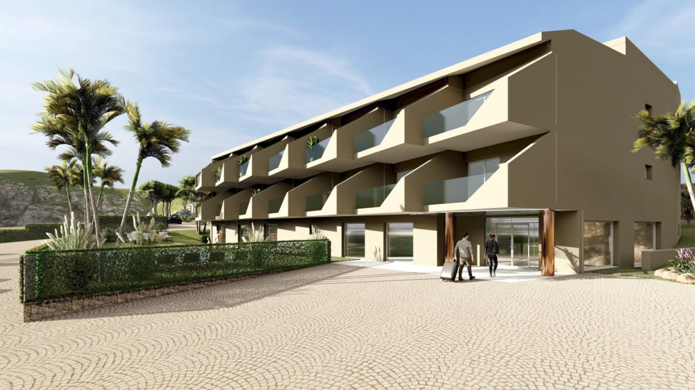 Fachada exterior del hotel boutique con balcones privados de cristal, entrada principal acristalada y acceso pavimentado con adoquines rodeado de vegetación.