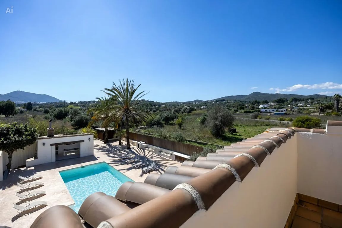 Vista elevada desde la planta superior que muestra la piscina de 5x10m, la cocina exterior y las vistas despejadas hacia el valle y las montañas.