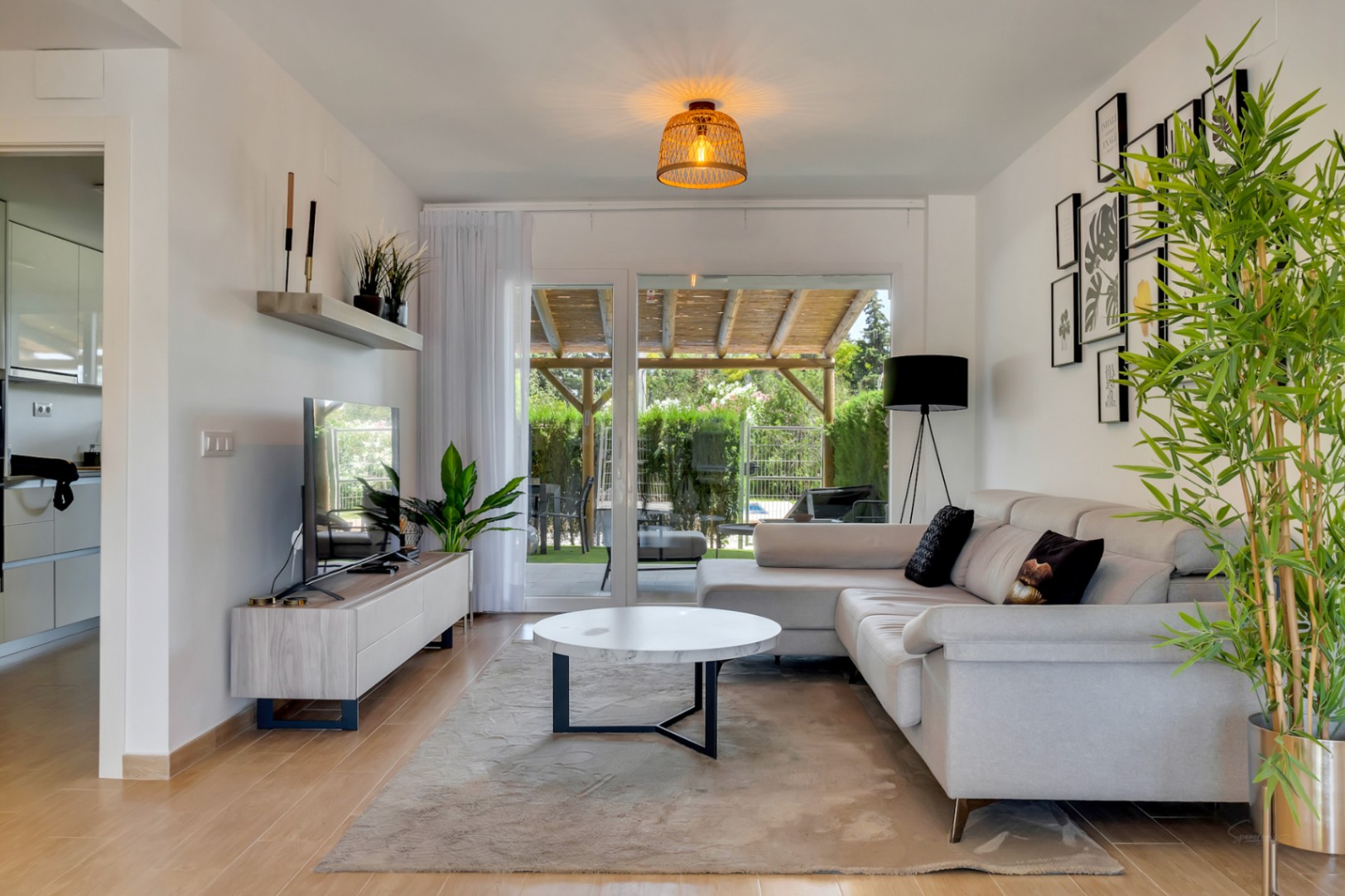 Salón de concepto abierto con suelos de gres porcelánico efecto madera, mobiliario contemporáneo y acceso directo al patio privado a través de grandes ventanales.