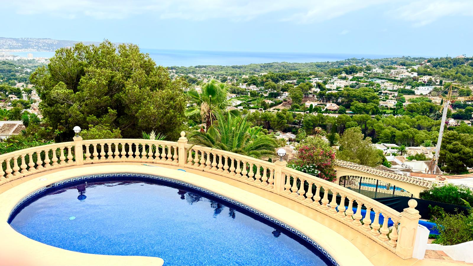 Piscina privada de gresite azul con balaustrada clásica, ofreciendo vistas panorámicas al mar Mediterráneo y al entorno natural de Jávea desde su posición elevada.