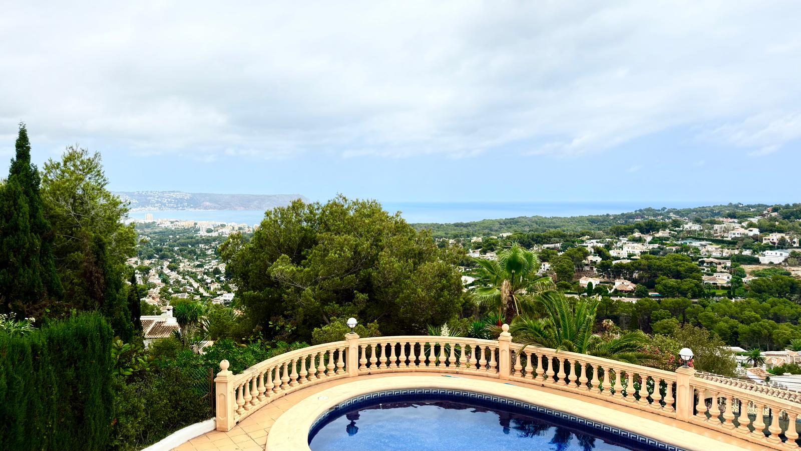 Vista panorámica desde la zona de la piscina, destacando la balaustrada clásica y las vistas despejadas hacia la bahía de Jávea y el mar Mediterráneo.