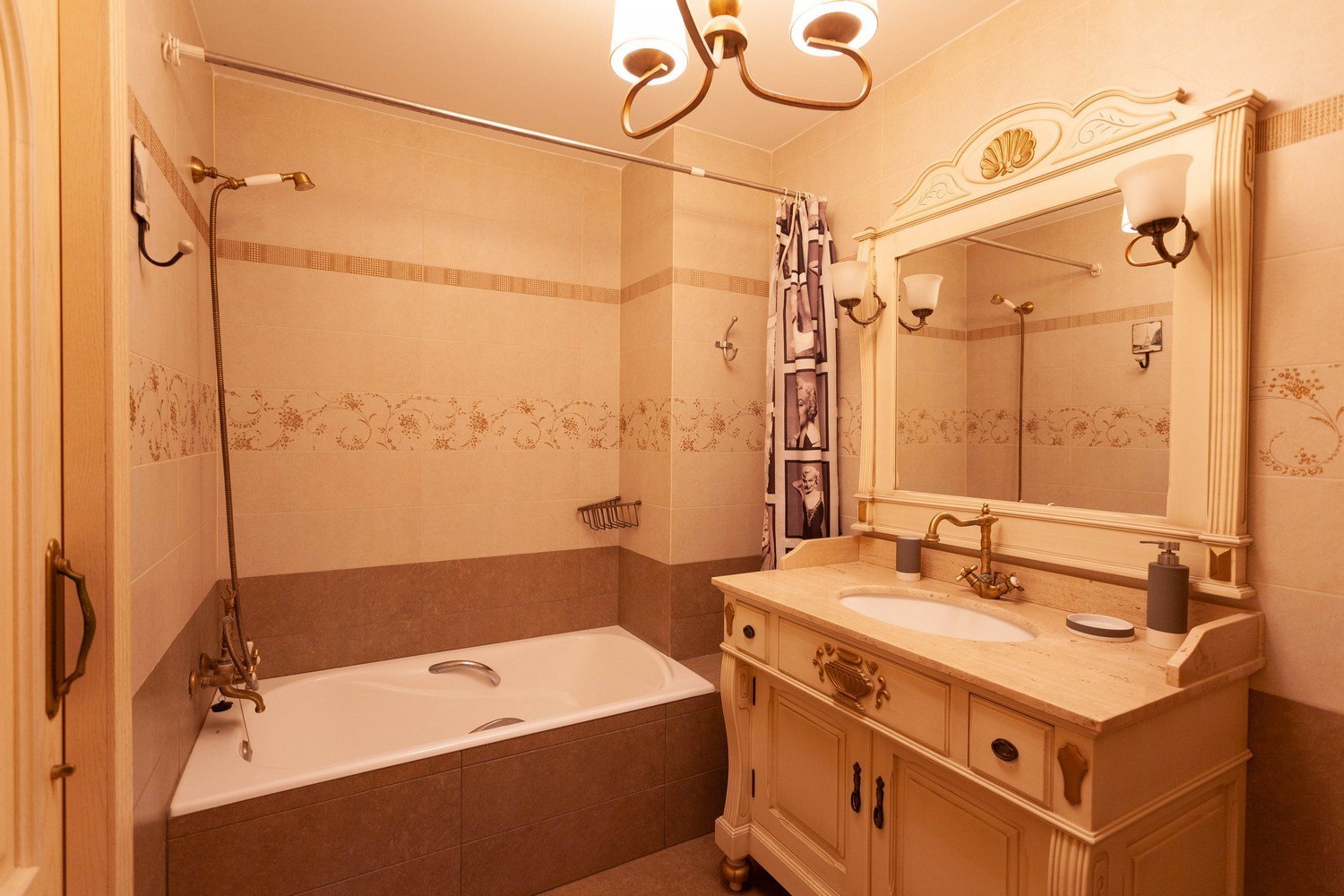 Cuarto de baño clásico con bañera, lavabo con encimera de mármol y espejo ornamentado.