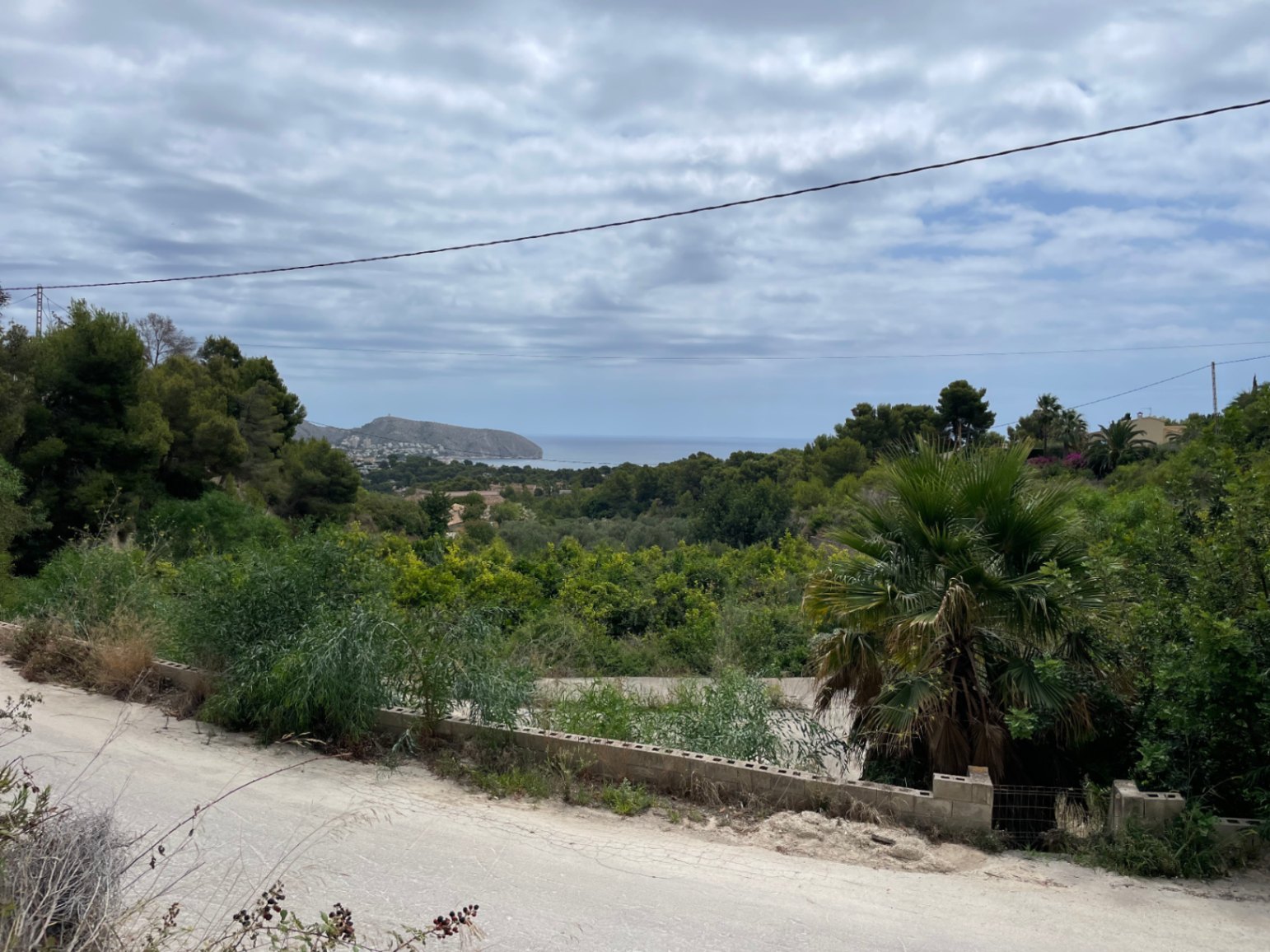 Vista panorámica al mar Mediterráneo y al Cap d'Or desde la parcela elevada, rodeada de vegetación autóctona y pinos en la zona de Benimeit.