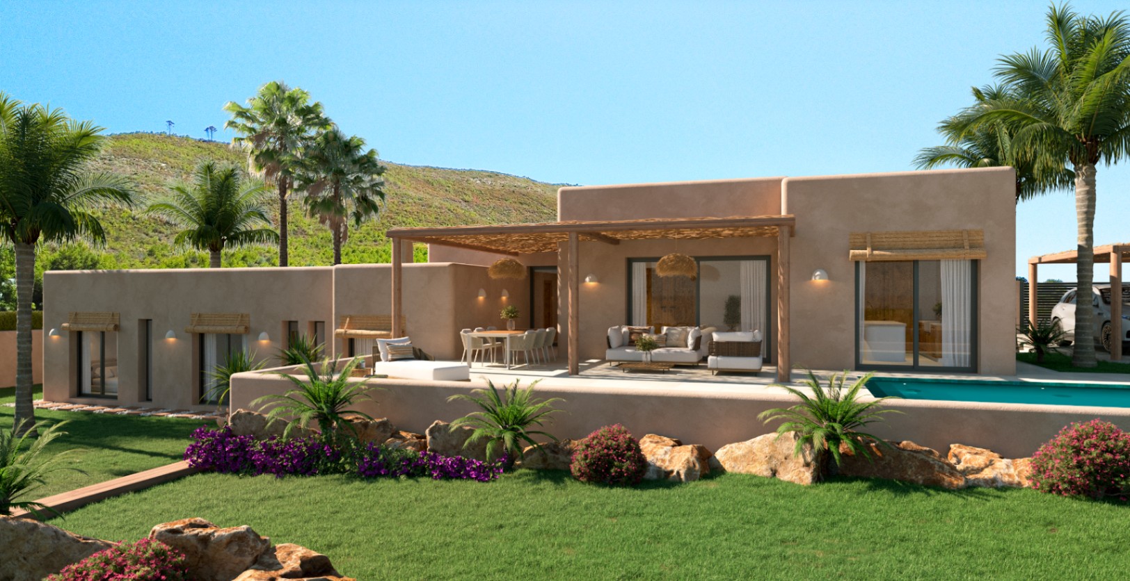 Fachada de tonos tierra con amplia terraza bajo pérgola de madera, zona de comedor exterior y piscina privada rodeada de un jardín mediterráneo con vistas a la montaña.