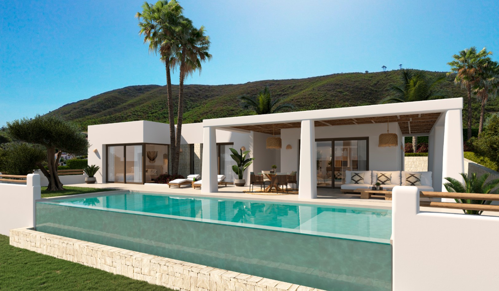 Villa de estilo ibicenco con piscina desbordante de pared acristalada, terraza cubierta con vigas de madera y vistas despejadas a las montañas de Jávea.