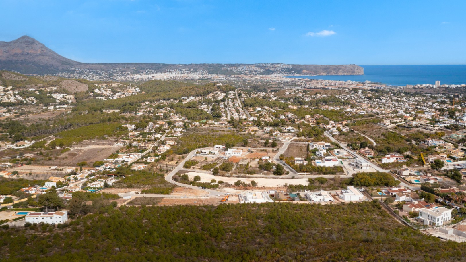 Vista aérea panorámica de la urbanización Lomas Del Rey en Jávea, mostrando la proximidad al Montgó y las vistas despejadas hacia la costa del Mediterráneo.