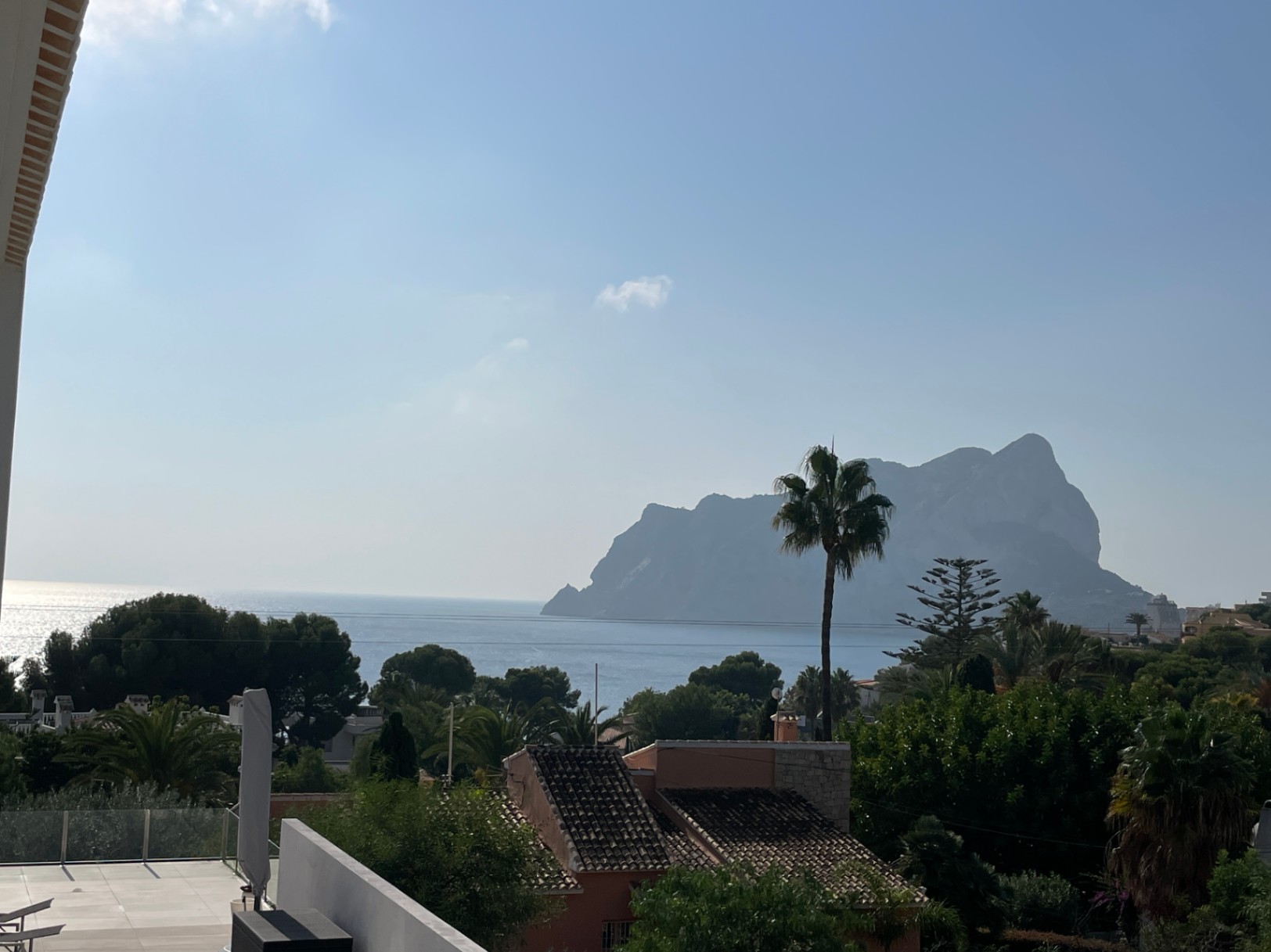 Vista elevada hacia el Peñón de Ifach y el mar Mediterráneo, destacando la vegetación autóctona y el entorno residencial de Bassetes.