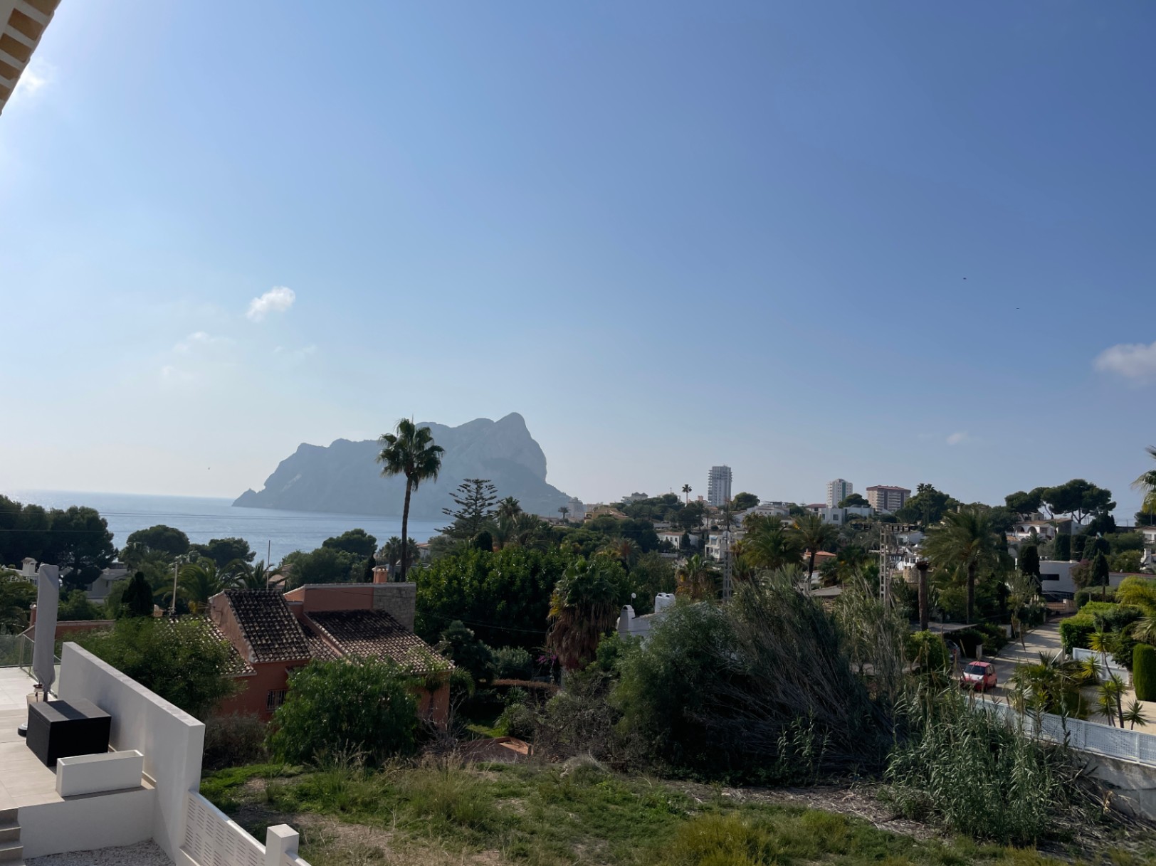Vistas panorámicas hacia el Peñón de Ifach y el Mediterráneo desde una posición elevada en Bassetes, Calpe, rodeada de vegetación autóctona.
