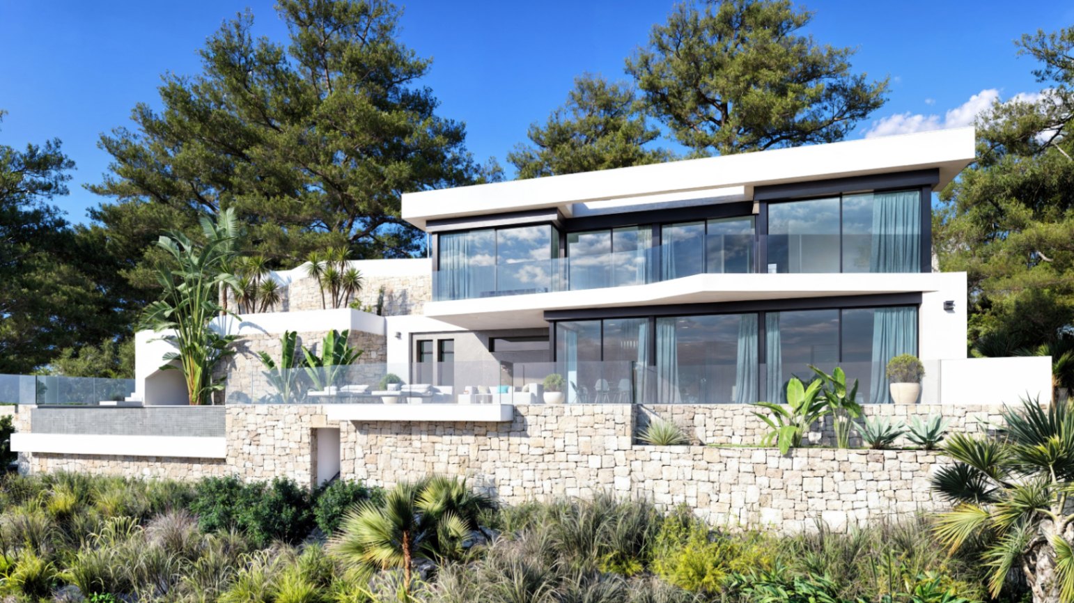 Fachada moderna de dos niveles con muros de piedra natural, amplios ventanales de suelo a techo y terrazas con barandillas de cristal integradas en un entorno mediterráneo.