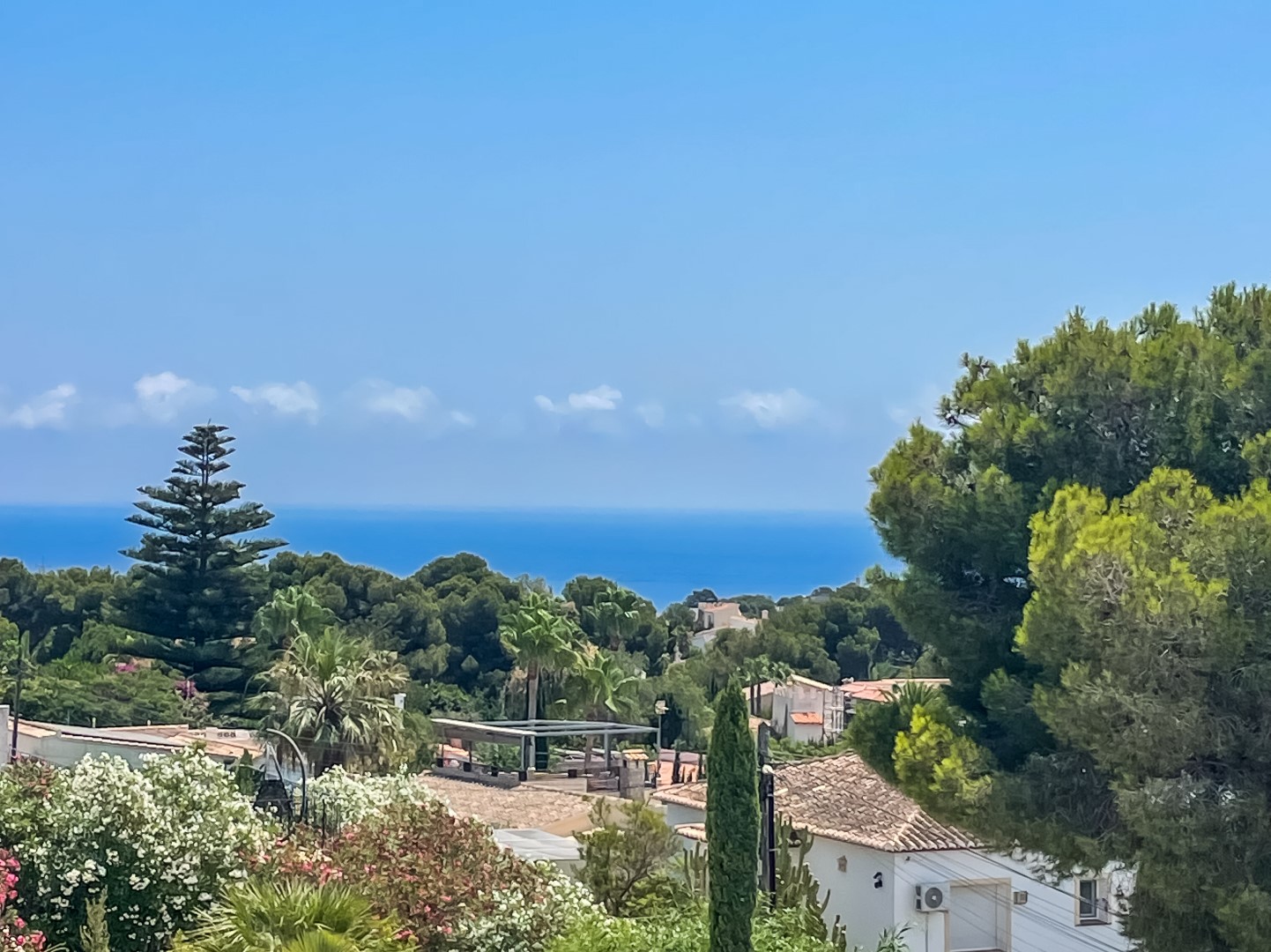 Vistas panorámicas al mar Mediterráneo desde la villa, rodeada de vegetación autóctona y los tejados tradicionales de la zona residencial de Balcón al Mar en Jávea.