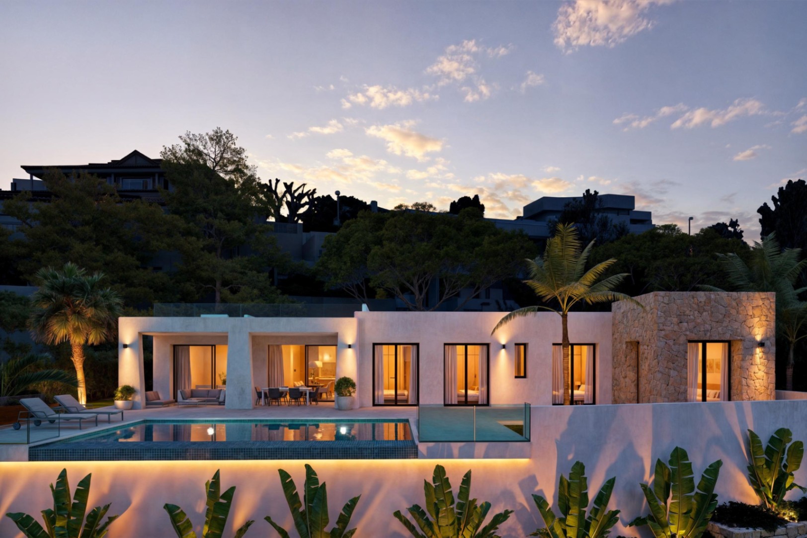 Vista exterior de la villa con piscina iluminada y fachada de piedra al atardecer.