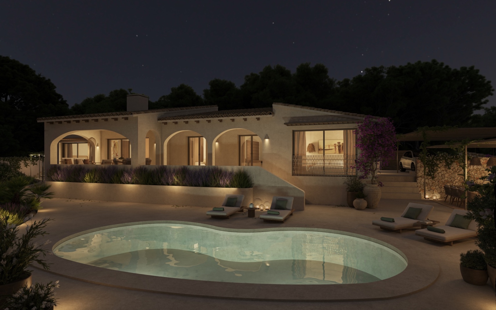 Vista nocturna de la villa con piscina de diseño orgánico, porches arqueados iluminados y amplias terrazas con tumbonas rodeadas de vegetación mediterránea.