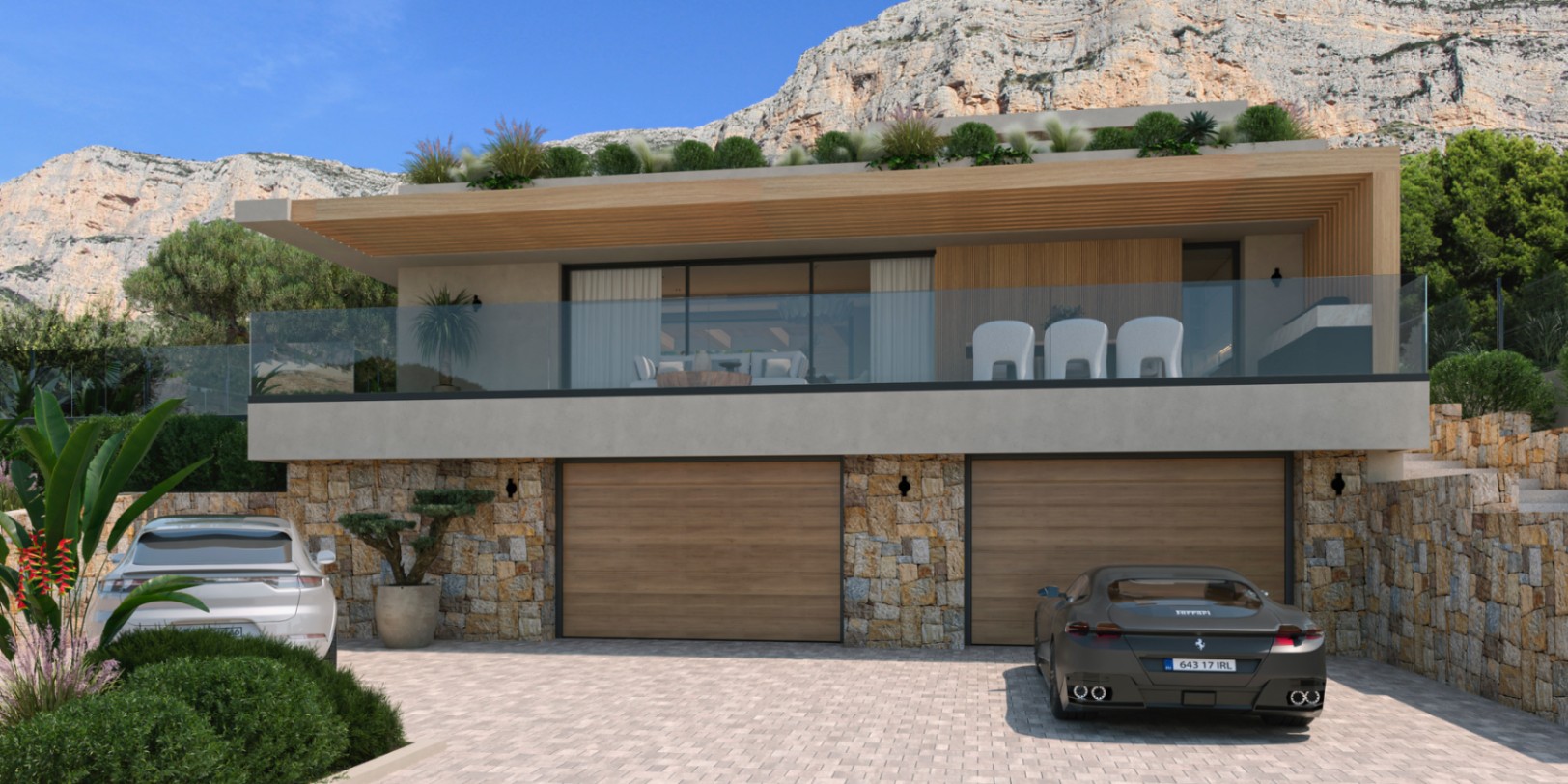 Fachada exterior con muros de piedra natural, garaje doble con portones de madera y una amplia terraza superior con barandillas de cristal bajo el Montgó.