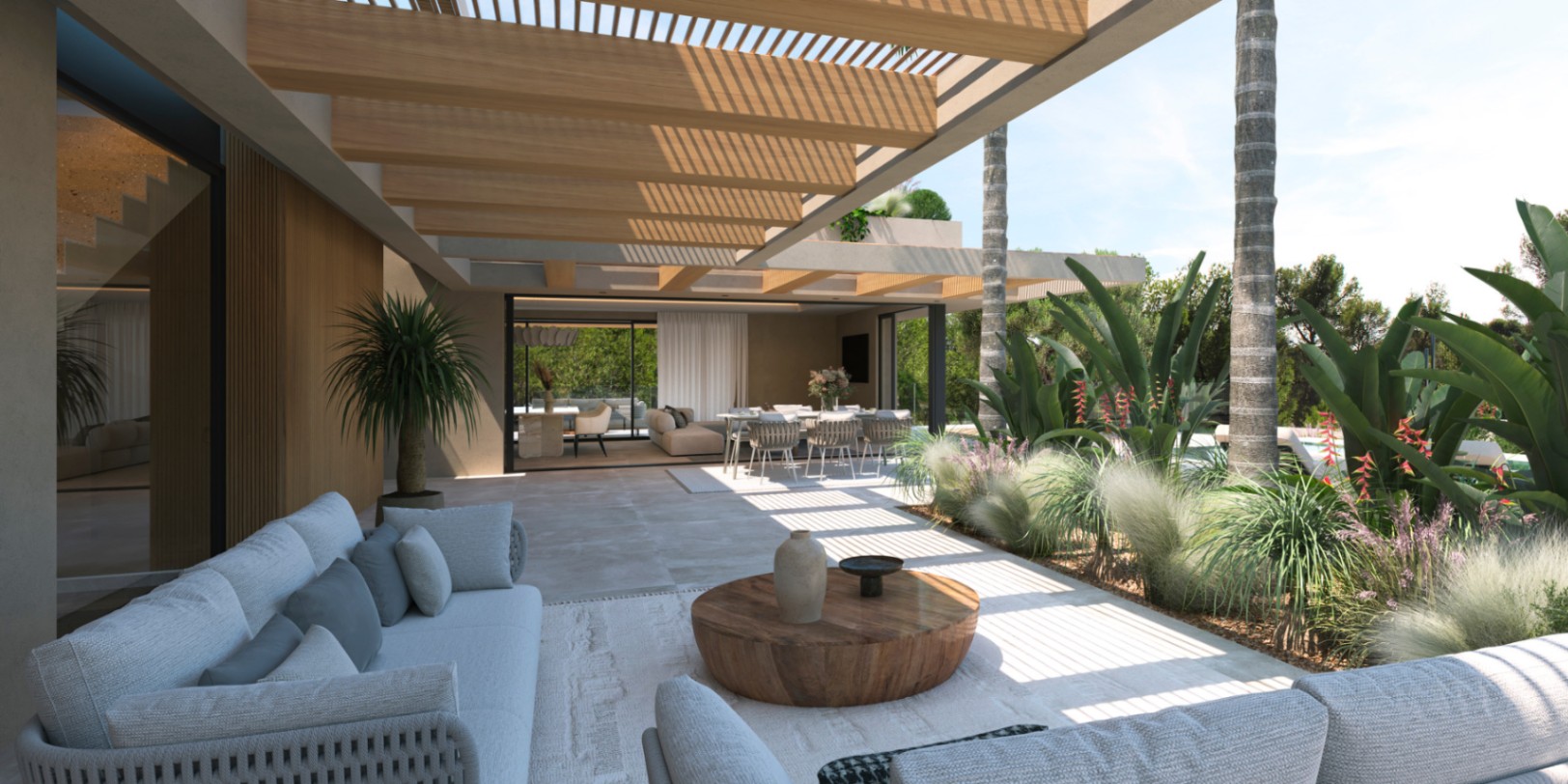 Terraza exterior con pérgola de vigas de madera, zona de estar con sofás de diseño y comedor al aire libre rodeado de vegetación mediterránea.