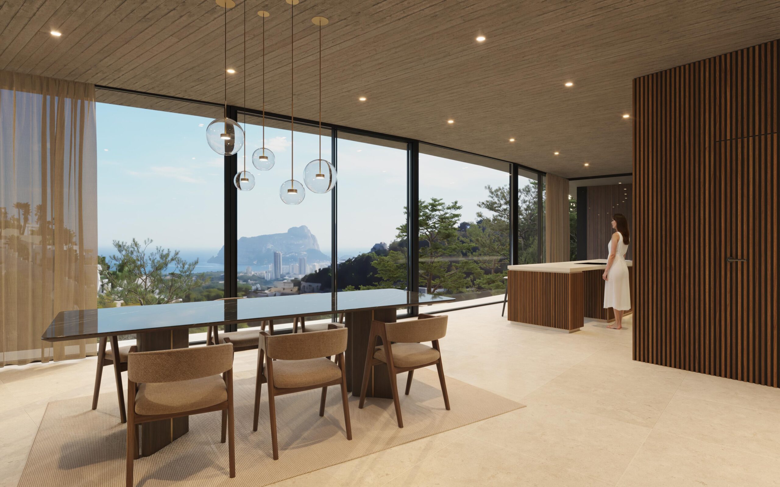 Comedor diáfano con mesa de mármol negro, luminarias esféricas y ventanales de gran formato con vistas panorámicas al Peñón de Ifach y la costa mediterránea.