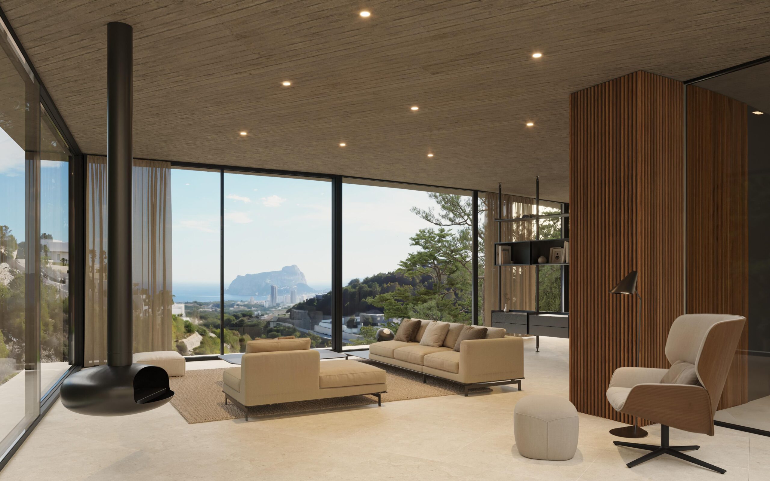 Salón moderno con chimenea suspendida, techos de hormigón y grandes ventanales con vistas panorámicas a la costa mediterránea y al Peñón de Ifach.