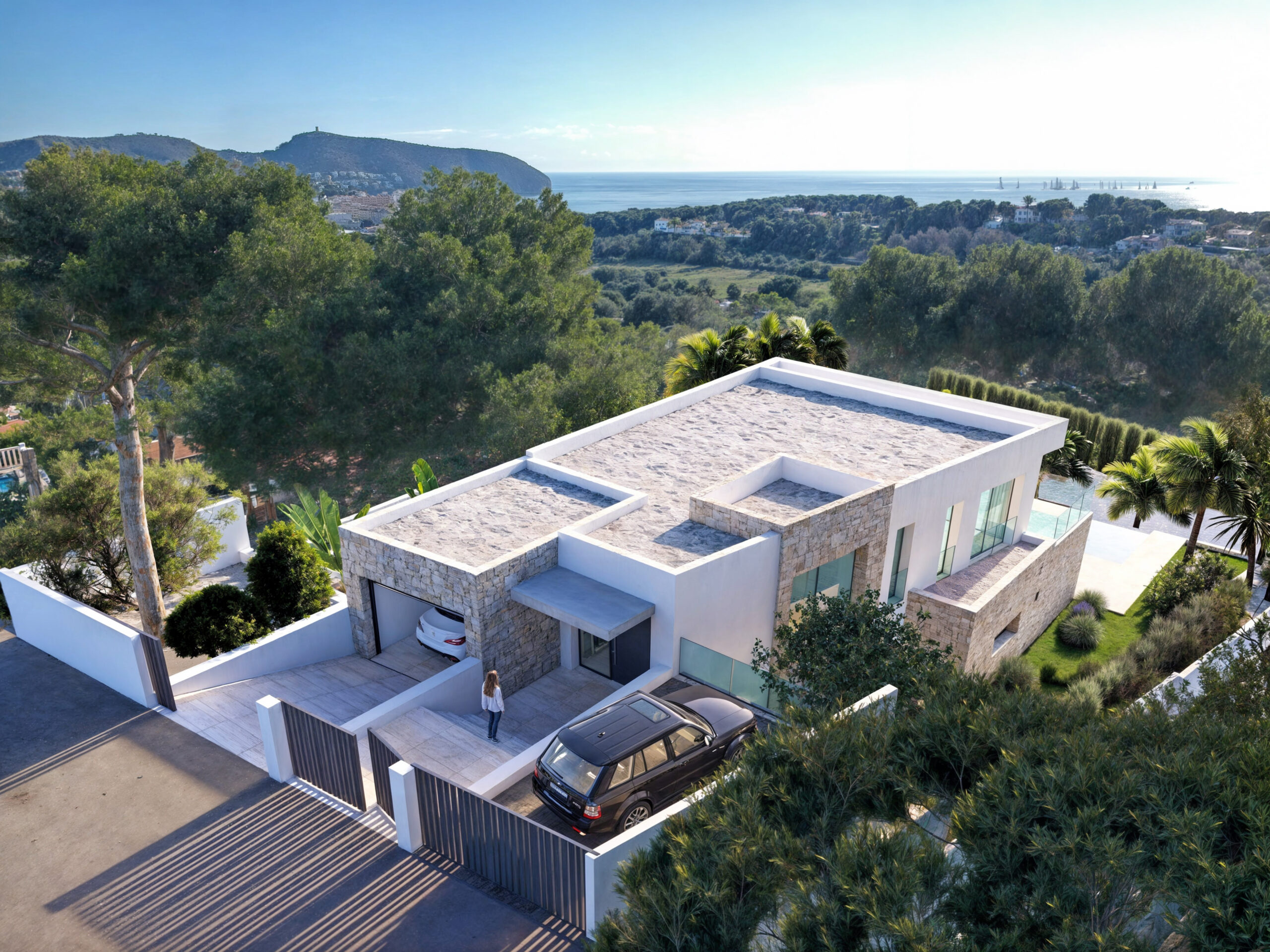 Exterior de villa moderna con revestimiento de piedra natural, entrada privada y cubiertas planas, ofreciendo vistas panorámicas al mar Mediterráneo y entorno boscoso.