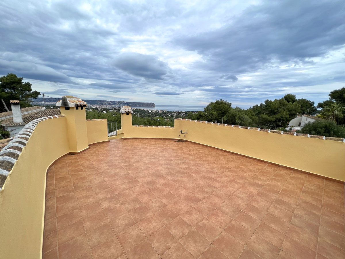 Terraza superior con suelo de baldosas cerámicas y muro curvo perimetral, ofreciendo vistas panorámicas al mar y al Cabo San Antonio en Jávea.