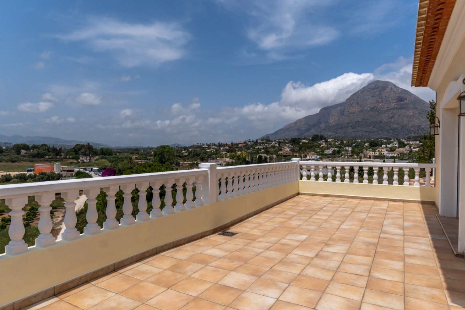 Terraza superior con suelo de gres cerámico y balaustrada blanca, ofreciendo vistas panorámicas despejadas hacia el macizo del Montgó y el valle de Jávea.