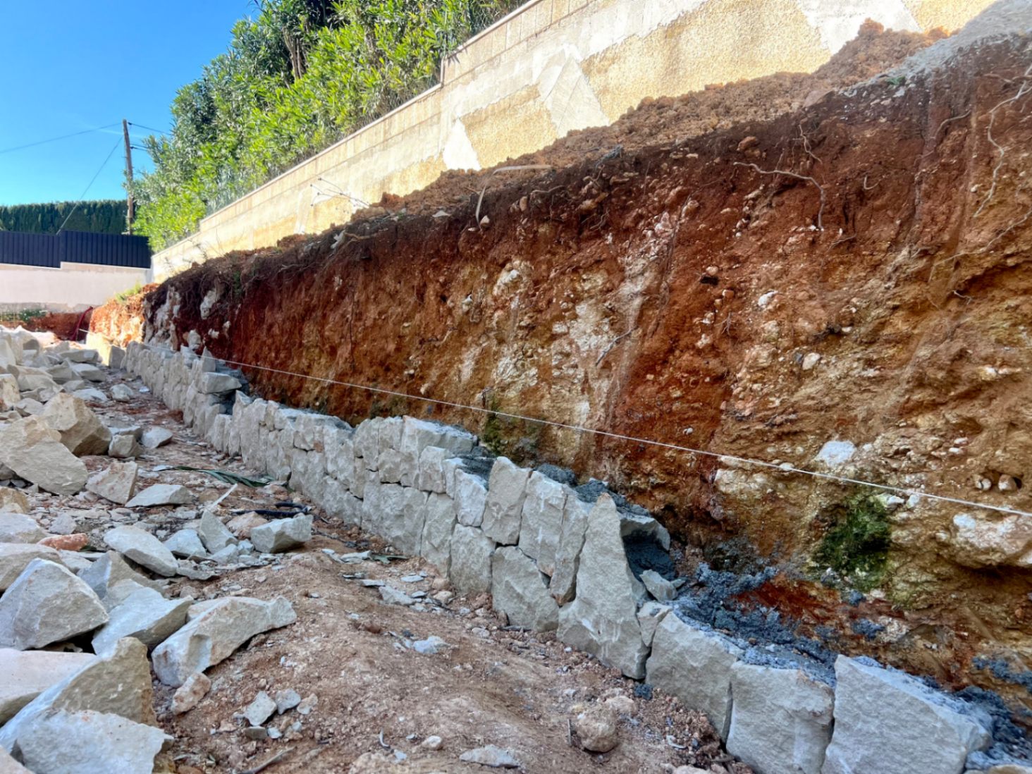 Inicio de las obras de cimentación y muros de contención mediante piedra natural tallada a mano en la parcela de El Garroferal.