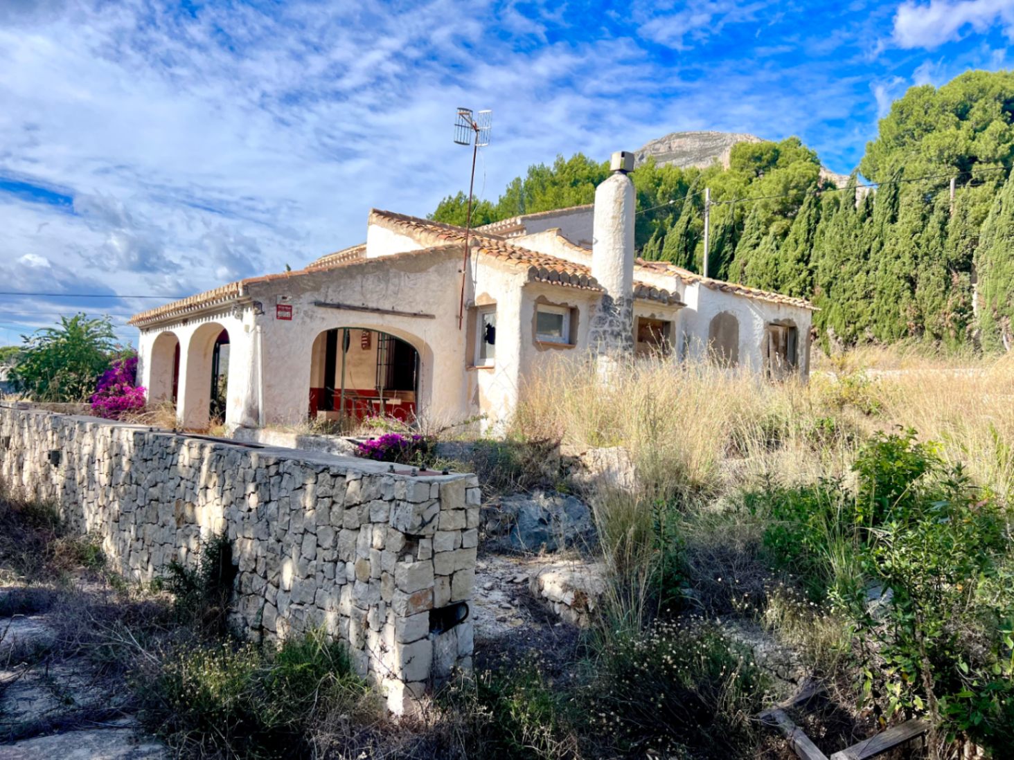 Chalet tradicional con naya de arcos y chimenea, situado frente al Montgó. La propiedad cuenta con un muro perimetral de piedra natural y requiere una reforma integral.