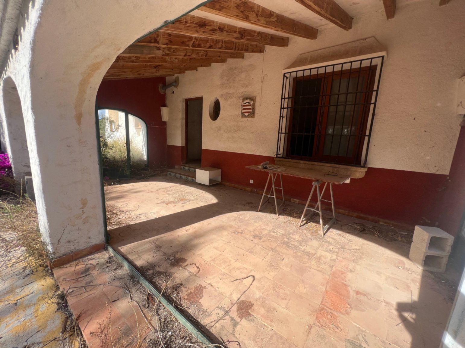 Naya cubierta con vigas de madera vista, suelos de terracota y arcos tradicionales. El espacio requiere reforma integral, conservando elementos arquitectónicos mediterráneos.