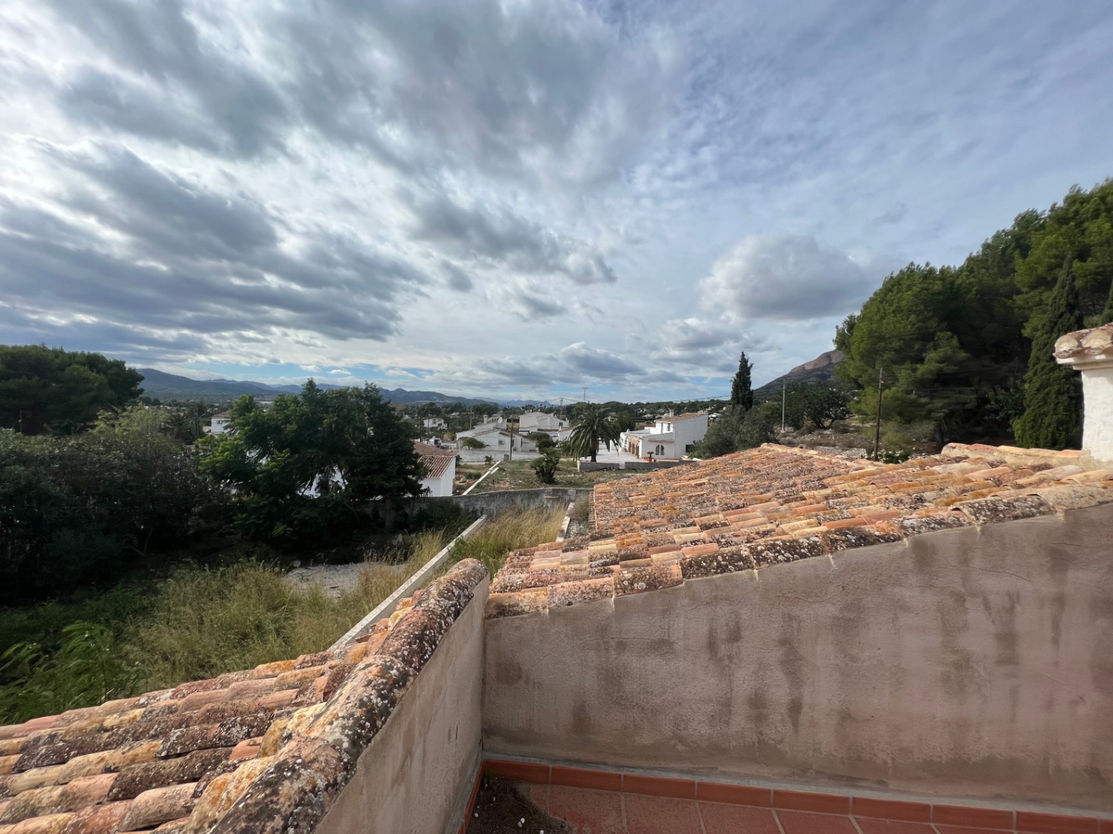 Vistas panorámicas desde la terraza superior hacia el valle de Jávea, destacando los tejados de teja tradicional y el entorno natural de la zona del Montgó.