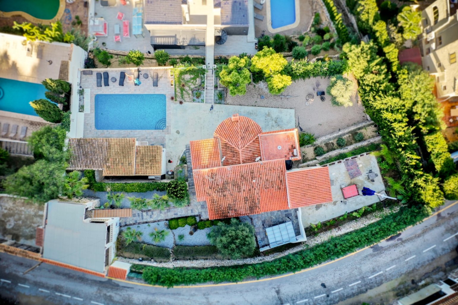 Vista aérea de la propiedad que muestra la distribución de la parcela, la piscina rectangular con terraza de piedra y los tejados de teja cerámica tradicional.