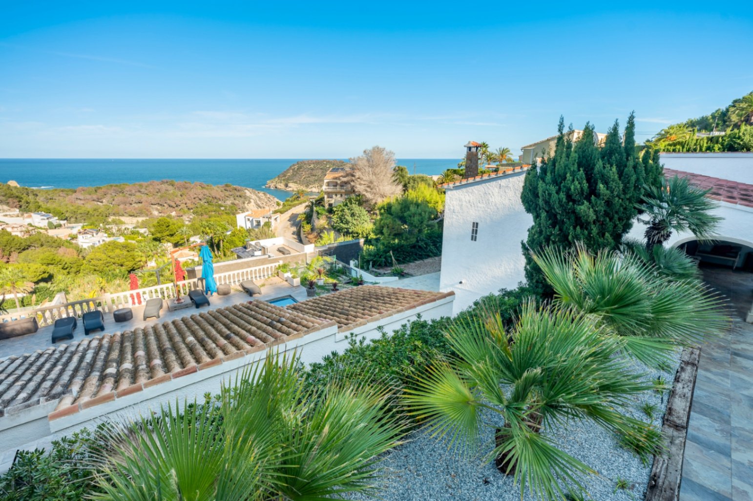 Vista panorámica desde la zona superior que muestra los tejados de teja cerámica, la terraza con hamacas y las amplias vistas al mar Mediterráneo en Portitxol.