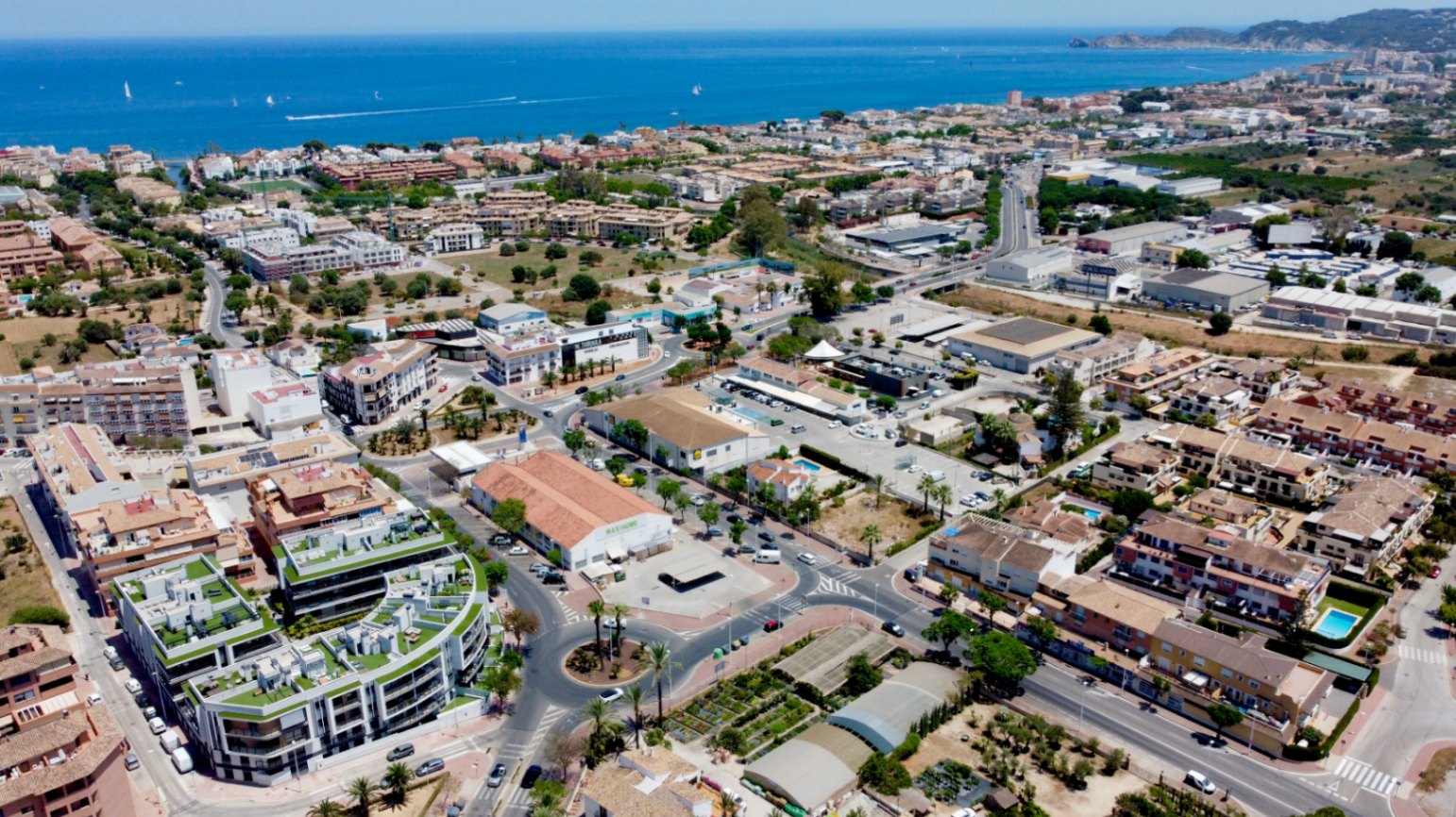 Vista aérea de Jávea que resalta la ubicación del complejo residencial moderno, situado a poca distancia de la costa mediterránea y servicios urbanos.