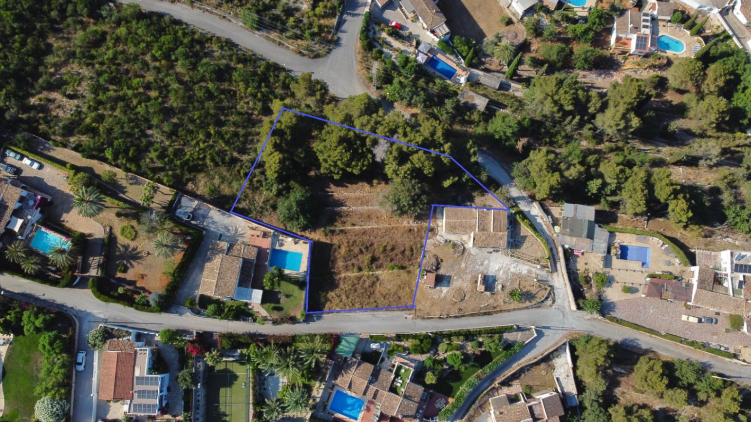 Vista aérea perimetrada de la parcela urbana de 1.908 m² en Jávea, destacando su topografía aterrazada, zona de pinada y ubicación en un entorno residencial consolidado.