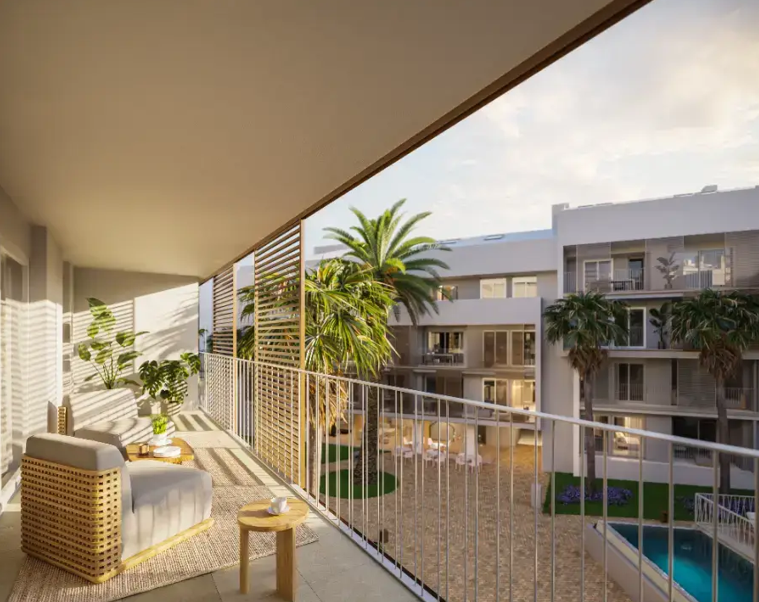 Terraza cubierta con barandilla metálica blanca y celosías de madera, equipada con mobiliario de exterior y vistas a la piscina y jardines comunitarios.