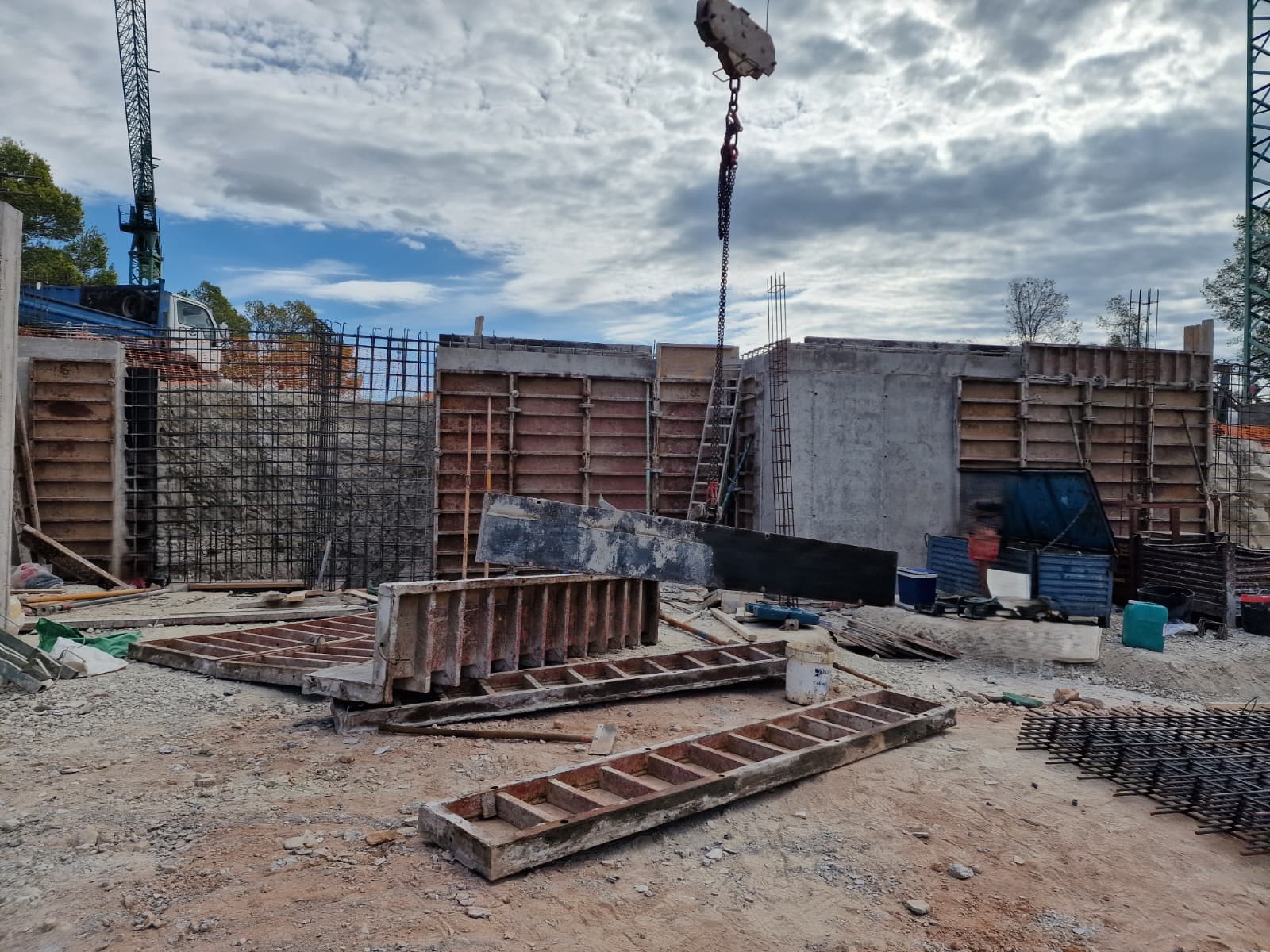 Avance de la fase estructural con muros de hormigón armado, encofrados metálicos y grúa en la obra de esta villa en Moraira.