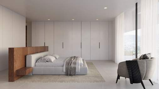 Dormitorio principal con cabecero divisor de madera, armarios empotrados de suelo a techo y amplios ventanales con vistas a las montañas.