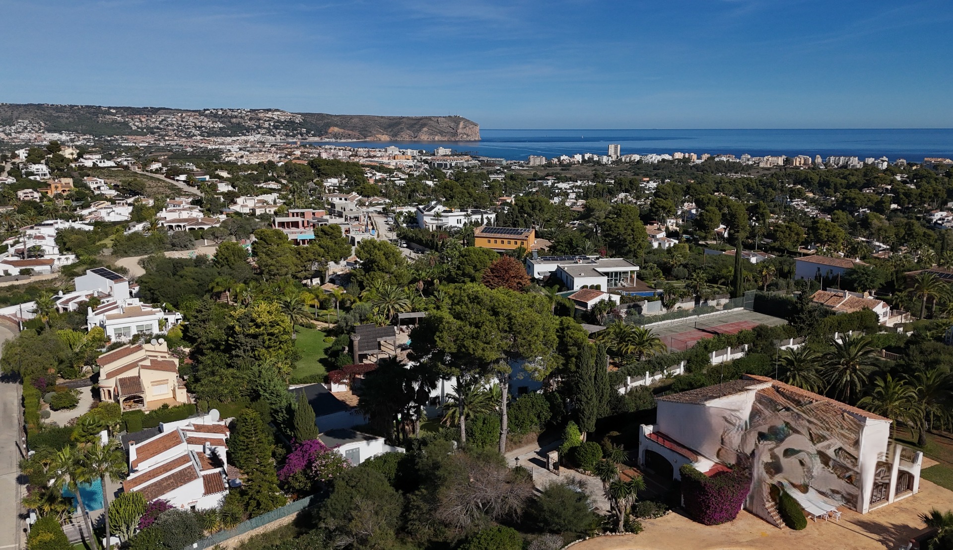 Vista aérea panorámica de la zona residencial de Pinosol en Jávea, mostrando la proximidad al mar Mediterráneo y el emblemático Cabo de San Antonio.