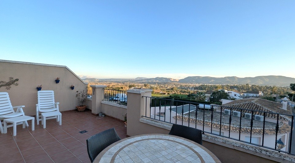 Amplia terraza solárium con suelos de gres, zona de comedor exterior y vistas panorámicas despejadas hacia el valle y las montañas de Jesús Pobre.