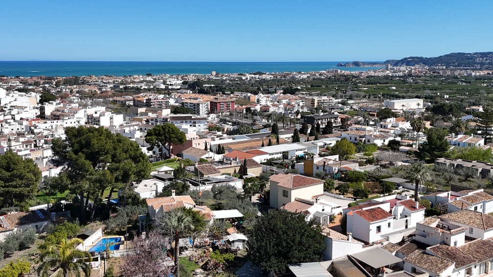 Vista panorámica desde la terraza sobre los tejados de Jávea Pueblo, con vistas al mar Mediterráneo y la línea costera en el horizonte.