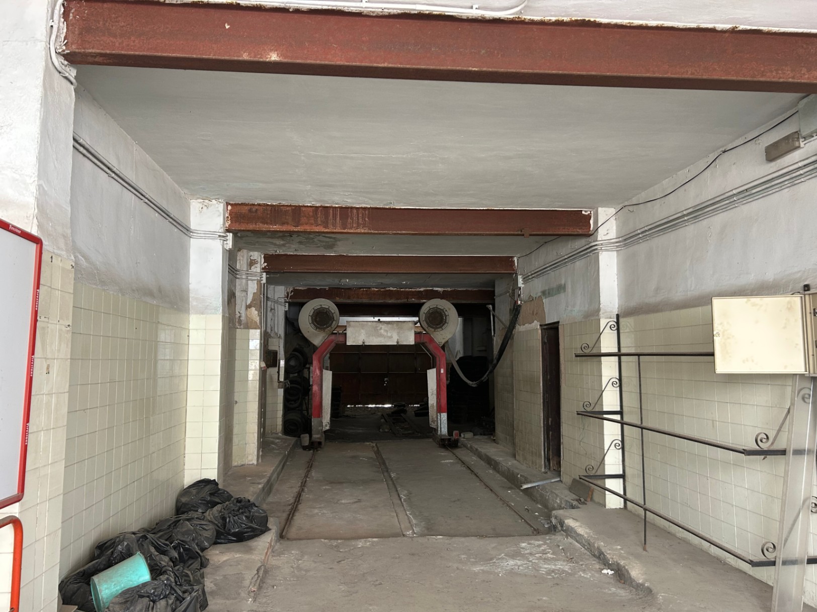 Local comercial de 175 m² en planta baja con techos altos, vigas de acero vistas y rieles industriales, ofreciendo gran potencial para reconversión en garaje o loft.