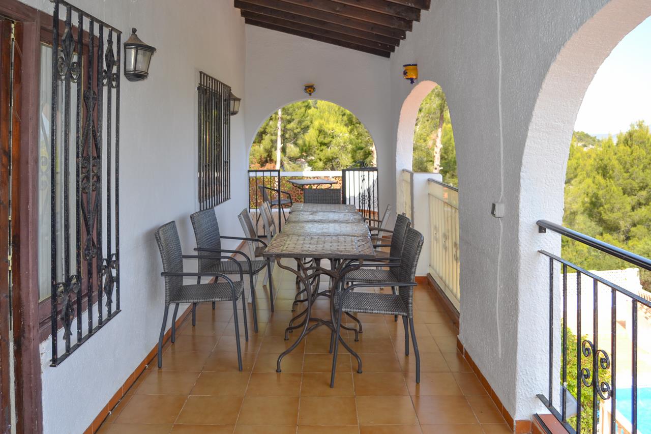 Naya cubierta con arcos tradicionales, vigas de madera oscura y suelos de terracota. Incluye una zona de comedor exterior con vistas al entorno natural arbolado.