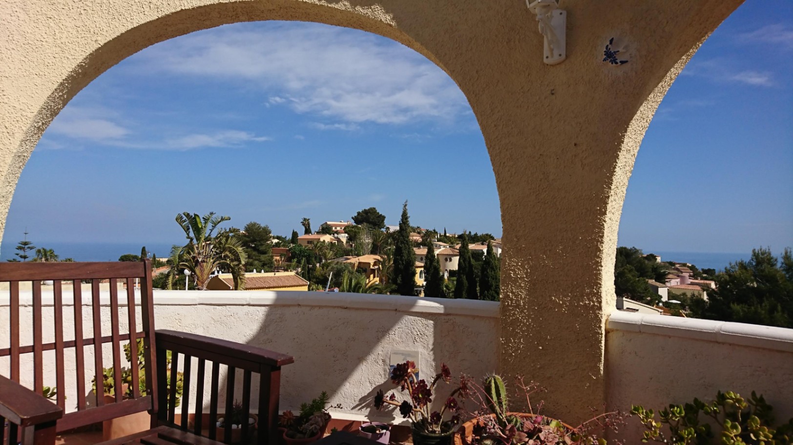 Vista desde la naya con arcos tradicionales hacia el mar Mediterráneo. Incluye mobiliario de madera, plantas suculentas y vistas despejadas a la urbanización Cumbre del Sol.