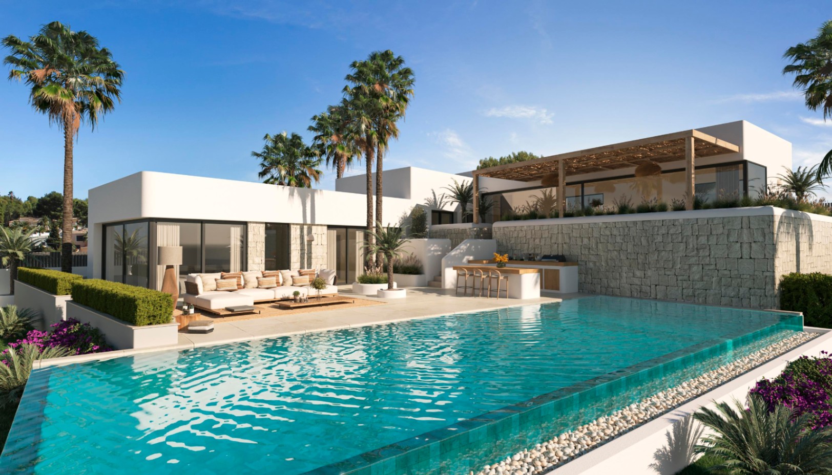 Vista exterior con piscina infinita de borde de cristal, zona de estar y cocina de verano integrada frente a muros de piedra natural y palmeras.