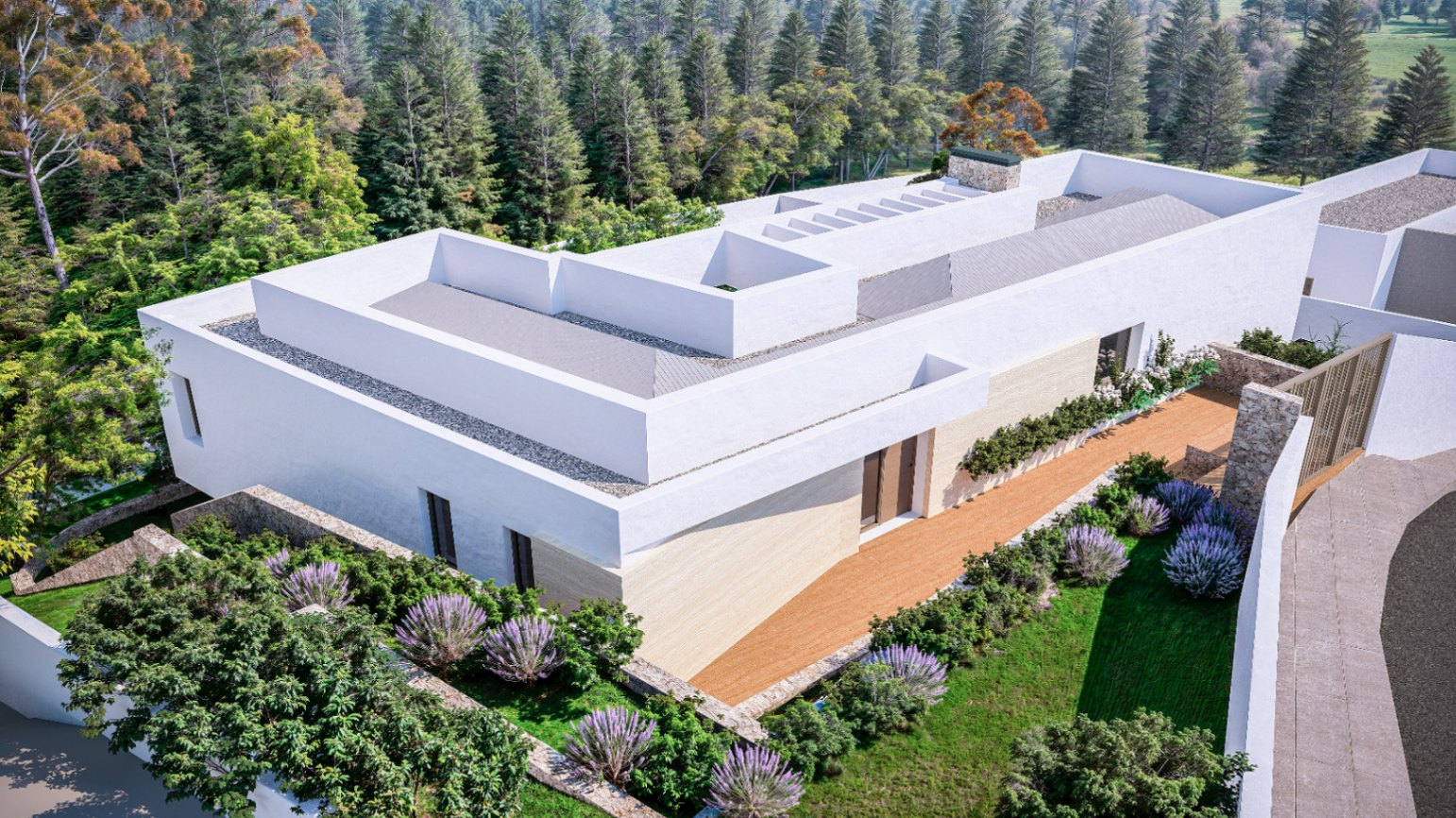 Vista aérea de la villa moderna con fachada blanca y muros de piedra, rodeada de jardines con lavanda y un frondoso bosque de pinos.