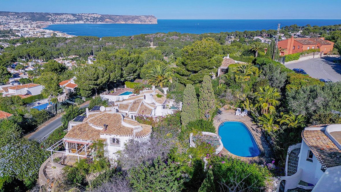 Vista aérea de la propiedad con arquitectura tradicional, piscina privada y vistas panorámicas al mar Mediterráneo y la costa de Jávea.