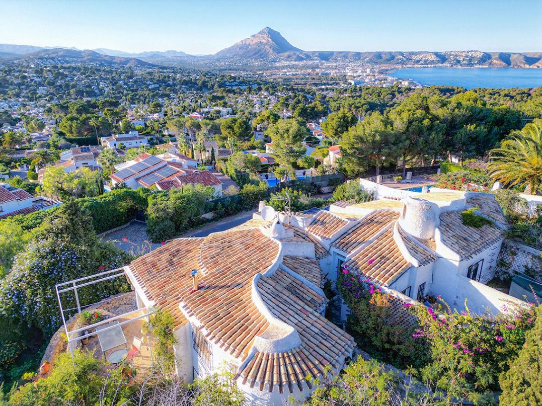 Vista aérea de la villa tradicional con tejados de teja curva, ofreciendo panorámicas despejadas hacia la bahía de Jávea y el macizo del Montgó.