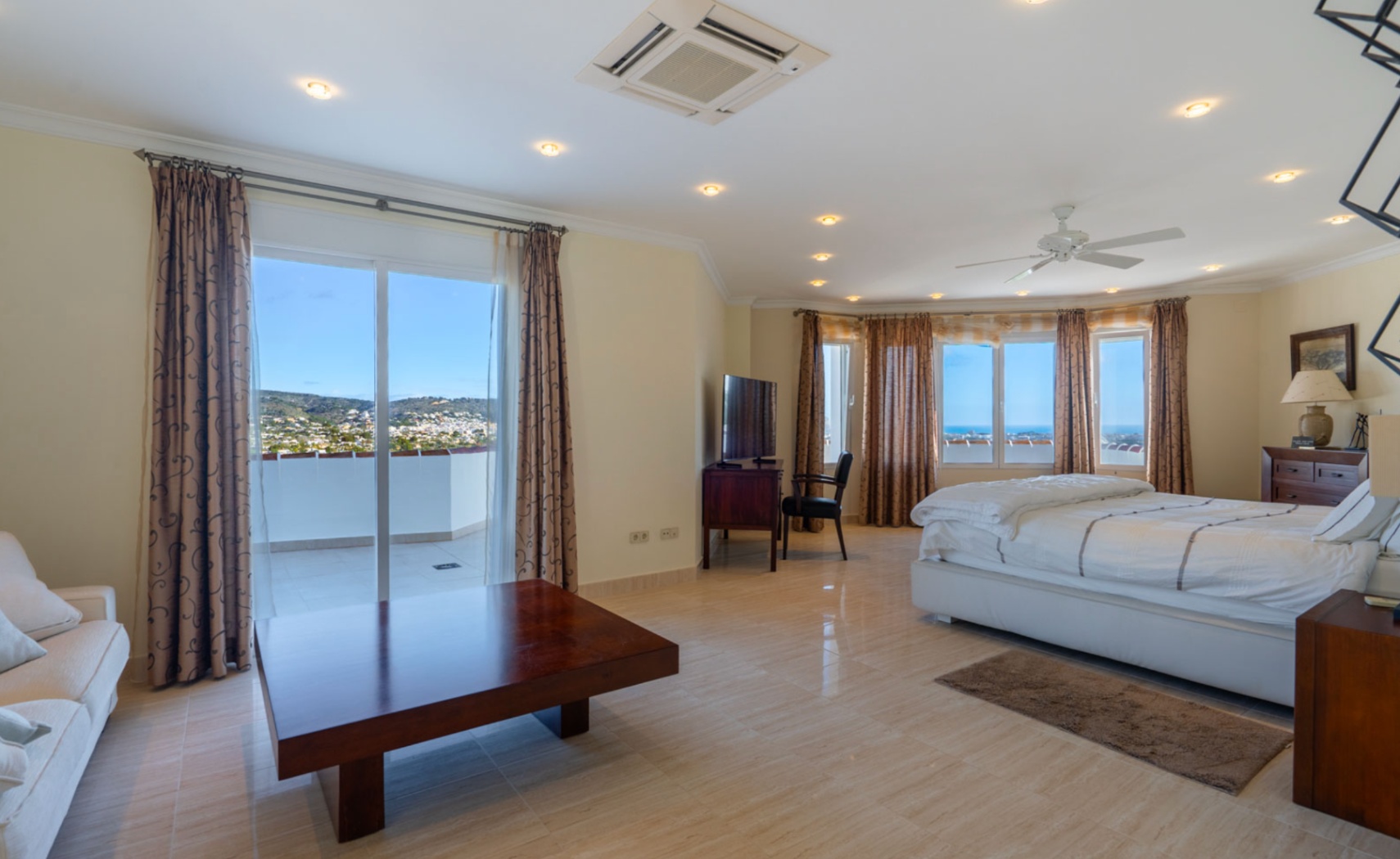 Dormitorio principal con acceso a terraza privada, suelos de gres pulido, aire acondicionado integrado y vistas panorámicas al mar y Jávea.